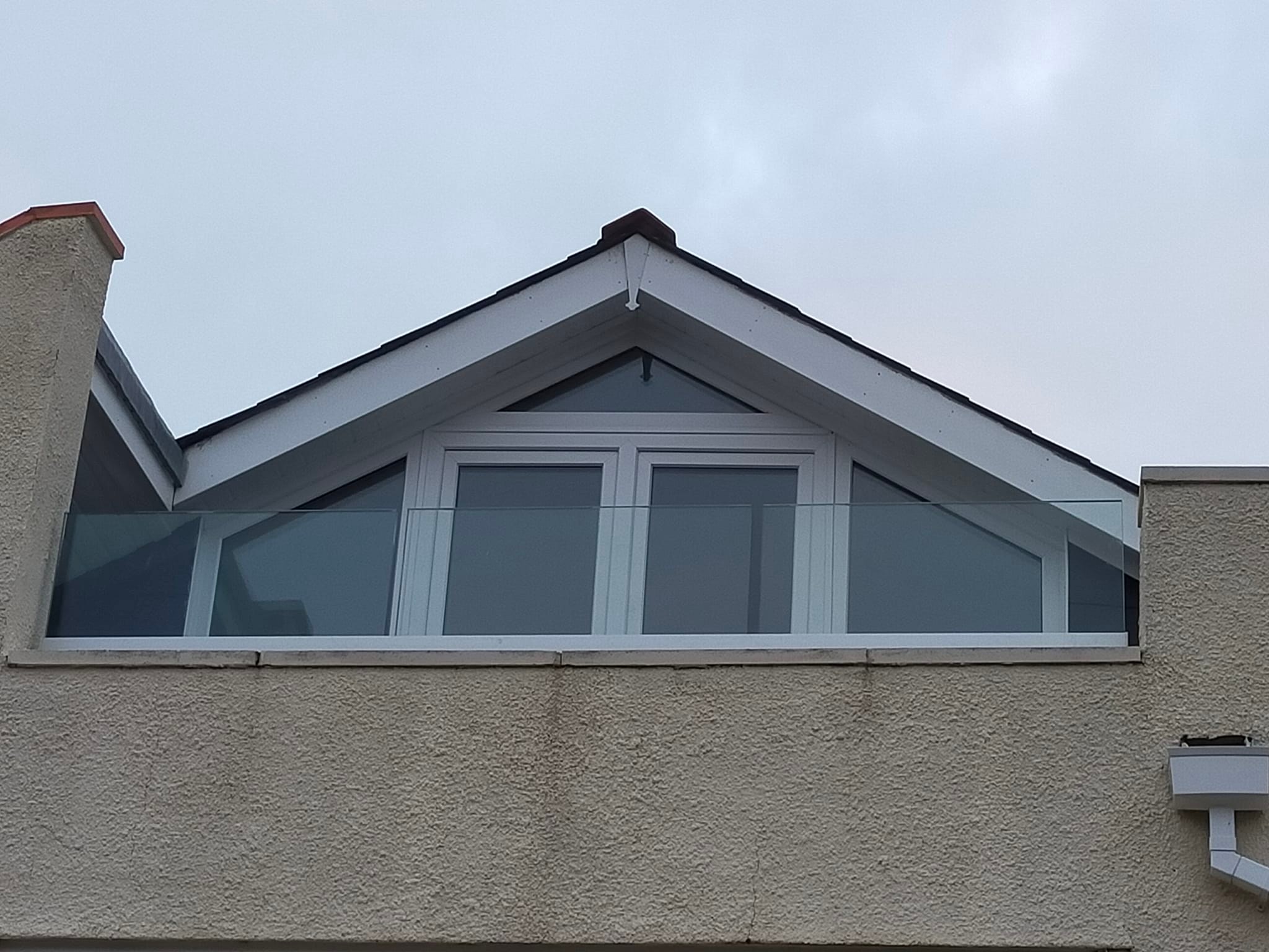 Loft conversion with glass balustrade and apex window by BBS Wales